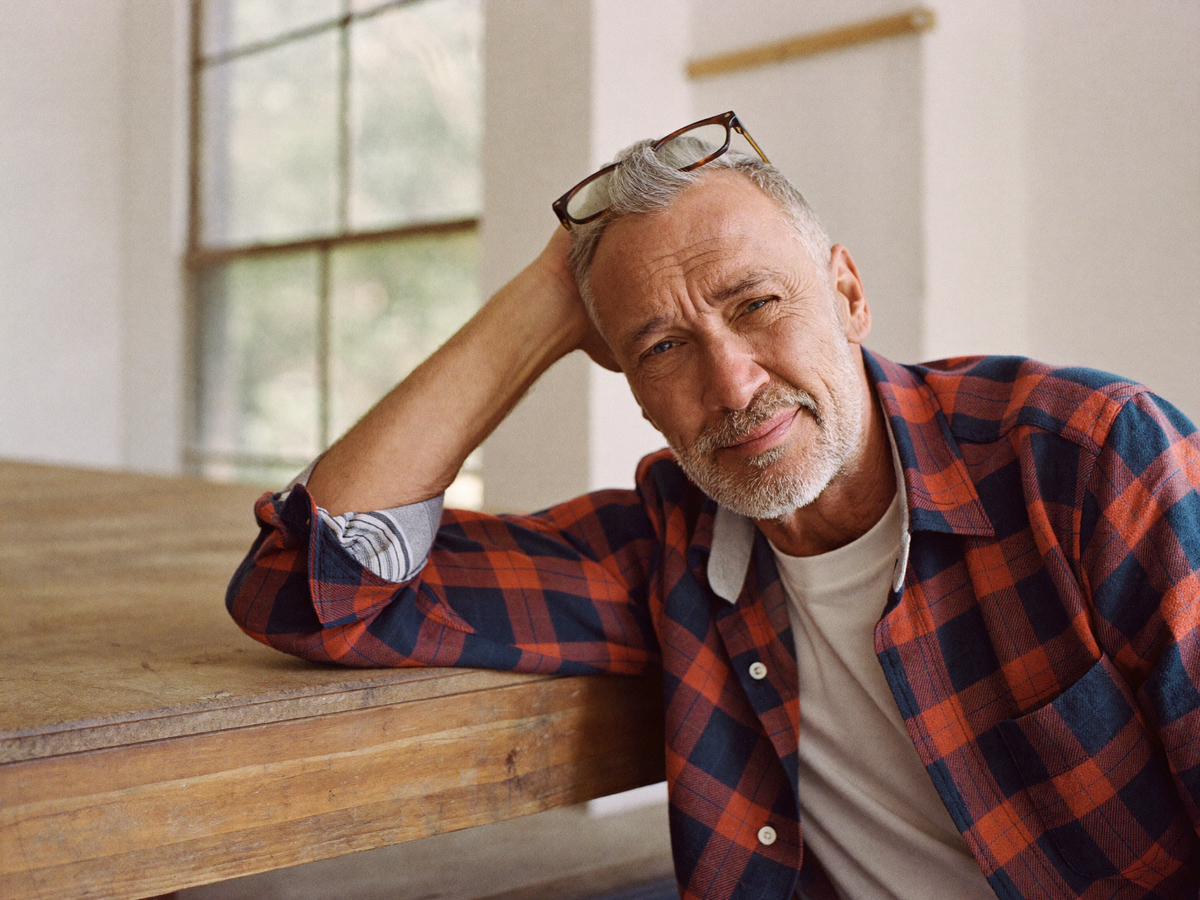 Man in a rust and navy brushed checked flannel overshirt at a workbench